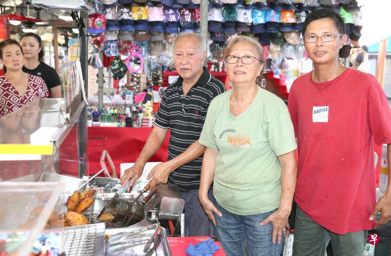 由何英夫妇与儿子(右一)经营的摊位,售卖俗称"蚝饼"的煎炸小吃。(吴承沄摄) 由何英夫妇与儿子(右一)经营的摊位,售卖俗称"蚝饼"的煎炸小吃。(吴承沄摄)