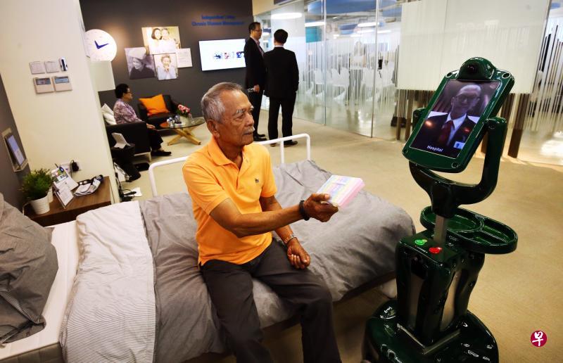 ▲未来,独居老人家中最得力的助手很可能是一台能帮助老人做复健、提醒他们按时吃药,甚至让医生进行视像问诊的机器人。图为TUV SUD智能乐龄看护服务@家居中心的模拟画面,医护人员出现在机器人的视频上,直接与病人沟通。(陈斌勤摄) ▲未来,独居老人家中最得力的助手很可能是一台能帮助老人做复健、提醒他们按时吃药,甚至让医生进行视像问诊的机器人。图为TUV SUD智能乐龄看护服务@家居中心的模拟画面,医护人员出现在机器人的视频上,直接与病人沟通。(陈斌勤摄)