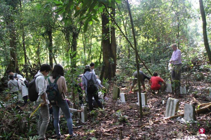 丁荷生教授(右一)亲自带领一群研究助理,到安莱盖路附近的热带树林寻找清朝古墓,并一一记录下来,作为研究我国最早华人移民的珍贵原始材料。(许源泰摄) 丁荷生教授(右一)亲自带领一群研究助理,到安莱盖路附近的热带树林寻找清朝古墓,并一一记录下来,作为研究我国最早华人移民的珍贵原始材料。(许源泰摄)