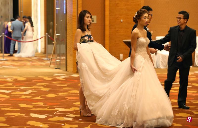 新人杨利蕙昨天和梁国荣在滨海湾金沙举办婚宴,在宾客都入席后,两人准备入场。在他们背后的宴会厅,另一对新人也正准备入场。滨海湾金沙昨天共有17对新人办婚宴,是开业以来最多的一次。(何家俊摄) 新人杨利蕙昨天和梁国荣在滨海湾金沙举办婚宴,在宾客都入席后,两人准备入场。在他们背后的宴会厅,另一对新人也正准备入场。滨海湾金沙昨天共有17对新人办婚宴,是开业以来最多的一次。(何家俊摄)