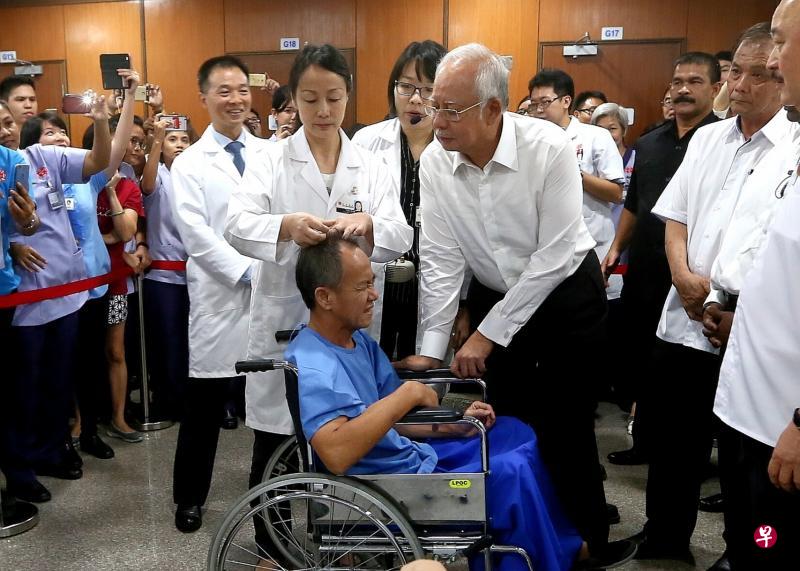 纳吉(病患旁右一)昨天首次访问吉隆坡同善医院,并通过讲解员的解说,观看一名中医师为病患进行传统治疗。(中国报) 纳吉(病患旁右一)昨天首次访问吉隆坡同善医院,并通过讲解员的解说,观看一名中医师为病患进行传统治疗。(中国报)