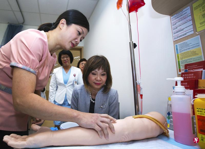 卓美丽(左)向环境及水源部兼卫生部高级政务部长许连碹博士(中),示范如何做静脉穿刺。(曾道明摄) 卓美丽(左)向环境及水源部兼卫生部高级政务部长许连碹博士(中),示范如何做静脉穿刺。(曾道明摄)