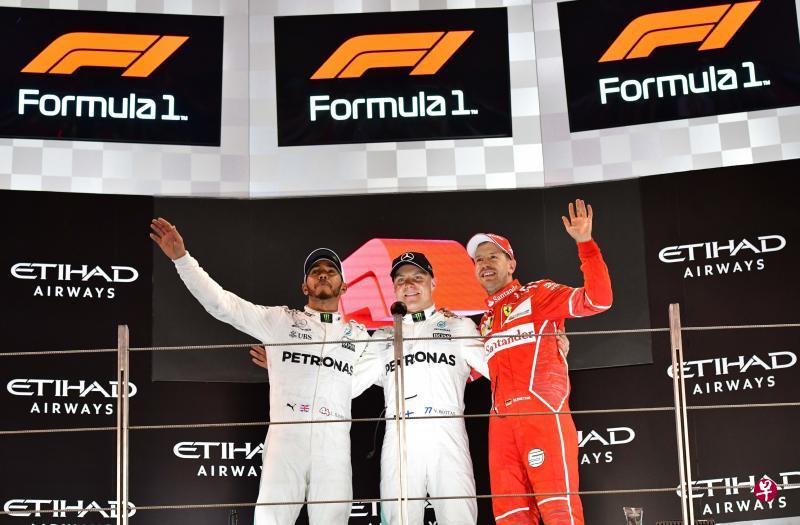 阿布扎比大奖赛前三名车手博塔斯(中)、哈密尔顿(左)与维特尔在领奖时,台上屏幕出现了新的F1标志。(法新社) 阿布扎比大奖赛前三名车手博塔斯(中)、哈密尔顿(左)与维特尔在领奖时,台上屏幕出现了新的F1标志。(法新社)