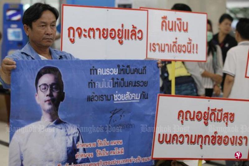 今年5月,一名受害者在警方特别调查部外拿着印有普迪头像的海报示威,要求当局对付他。(曼谷邮报) 今年5月,一名受害者在警方特别调查部外拿着印有普迪头像的海报示威,要求当局对付他。(曼谷邮报)