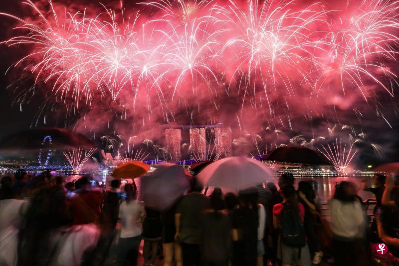 尽管下着倾盆大雨,不少公众依然撑着伞或穿上雨衣,在户外观看烟花表演。(林泽锐摄) 尽管下着倾盆大雨,不少公众依然撑着伞或穿上雨衣,在户外观看烟花表演。(林泽锐摄)