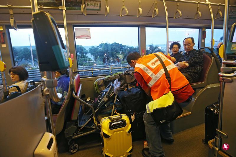乘客上接驳巴士后,SMRT工作人员会帮忙把大型行李放在巴士的轮椅位,并用绳子固定好。(叶振忠摄) 乘客上接驳巴士后,SMRT工作人员会帮忙把大型行李放在巴士的轮椅位,并用绳子固定好。(叶振忠摄)