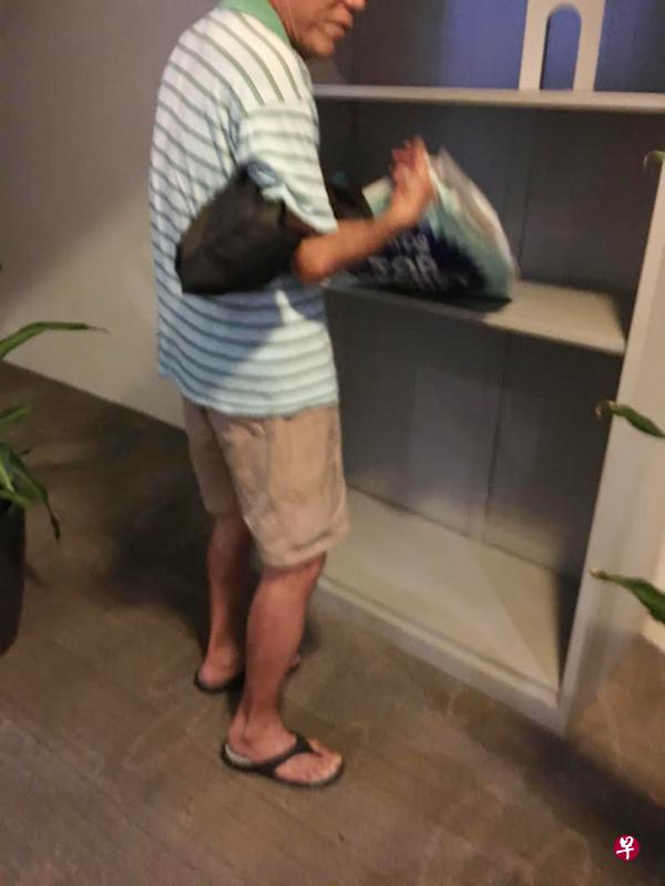 70岁的大叔把图书交换角落书架上的书籍拿走。(余明敏摄) 70岁的大叔把图书交换角落书架上的书籍拿走。(余明敏摄)