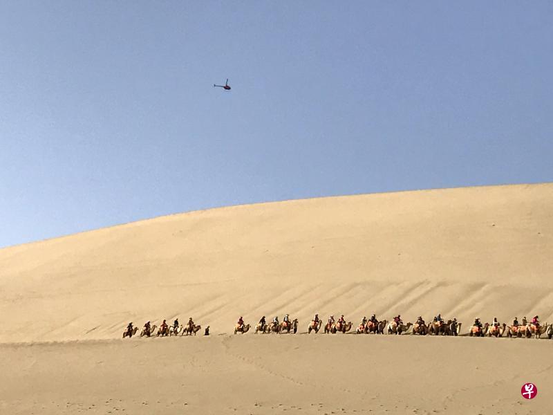 鸣沙山绵延40公里,金碧辉煌、巍峨壮观。长长的驼队行走在沙丘上,驼铃声声,一路逶迤。(苏亚华摄) 鸣沙山绵延40公里,金碧辉煌、巍峨壮观。长长的驼队行走在沙丘上,驼铃声声,一路逶迤。(苏亚华摄)