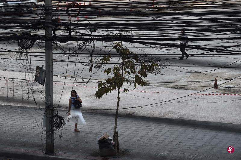 街头电线电缆密密麻麻、纠缠不清,是曼谷的“标志”之一;泰国当局决心让曼谷摆脱这些羁绊。(法新社) 街头电线电缆密密麻麻、纠缠不清,是曼谷的“标志”之一;泰国当局决心让曼谷摆脱这些羁绊。(法新社)