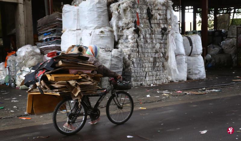 一名大婶载着纸皮和半篮子的汽水罐,到废纸回收站赚取生活费。(陈来福摄影) 一名大婶载着纸皮和半篮子的汽水罐,到废纸回收站赚取生活费。(陈来福摄影)