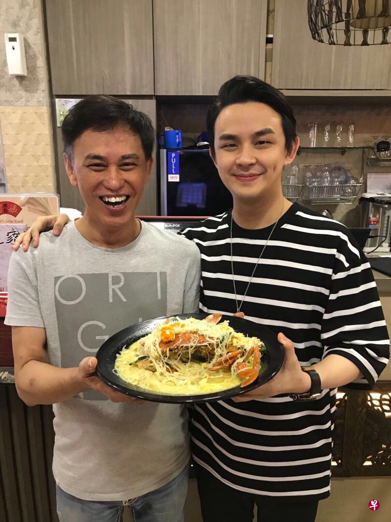 餐厅老板薛绍发(左)和儿子薛汉升(右)手捧着乳酪螃蟹上汤米粉。(受访者提供) 餐厅老板薛绍发(左)和儿子薛汉升(右)手捧着乳酪螃蟹上汤米粉。(受访者提供)