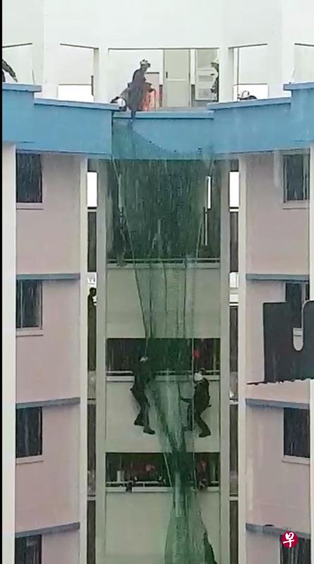 一名45岁华族女子昨午在义顺6道第289座组屋企图跳楼,民防人员冒着大雨从天台撒网救人。(读者提供) 一名45岁华族女子昨午在义顺6道第289座组屋企图跳楼,民防人员冒着大雨从天台撒网救人。(读者提供)