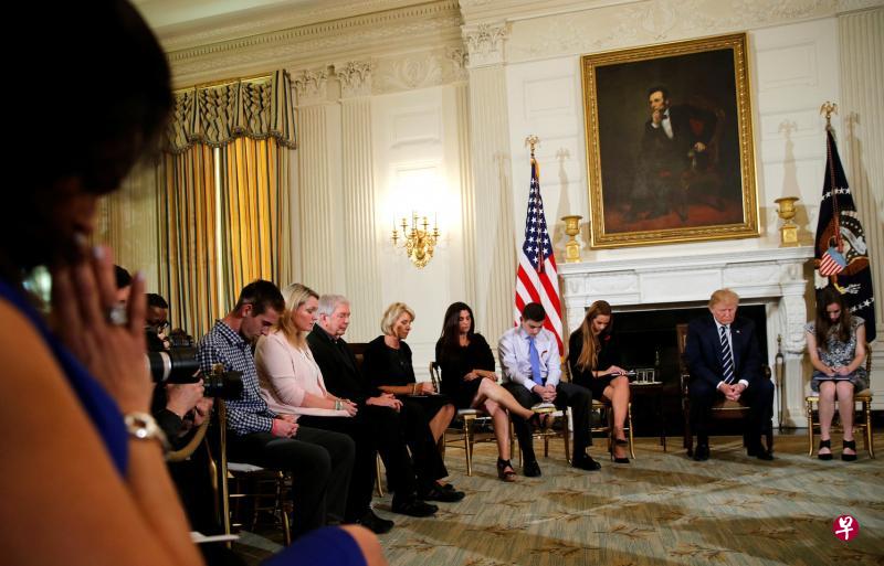 周三在白宫,特朗普(右二)与校园枪击案幸存者与家属会面时,为遇难者低头祈祷。(路透社) 周三在白宫,特朗普(右二)与校园枪击案幸存者与家属会面时,为遇难者低头祈祷。(路透社)