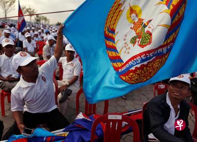 柬埔寨人民党的支持者在一个竞选集会上举起该党旗帜。(路透社) 柬埔寨人民党的支持者在一个竞选集会上举起该党旗帜。(路透社)
