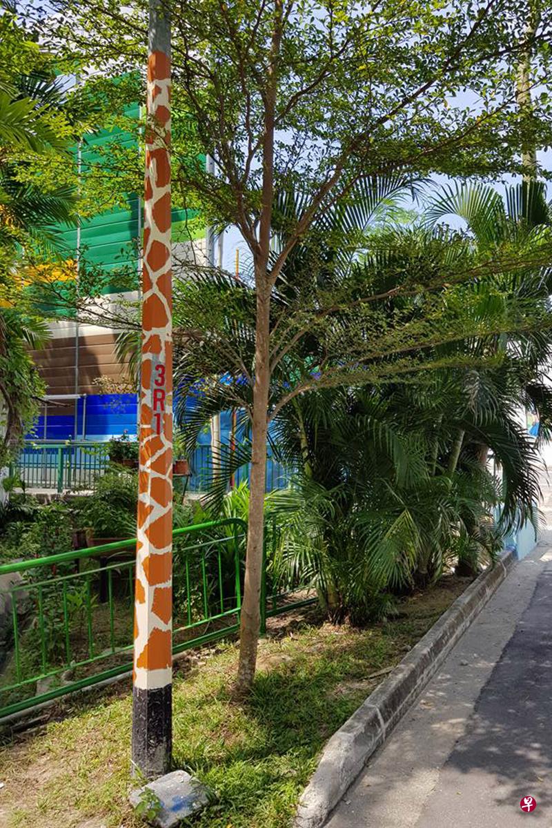 沈锐华将灯柱漆上长颈鹿花纹。(受访者提供) 沈锐华将灯柱漆上长颈鹿花纹。(受访者提供)