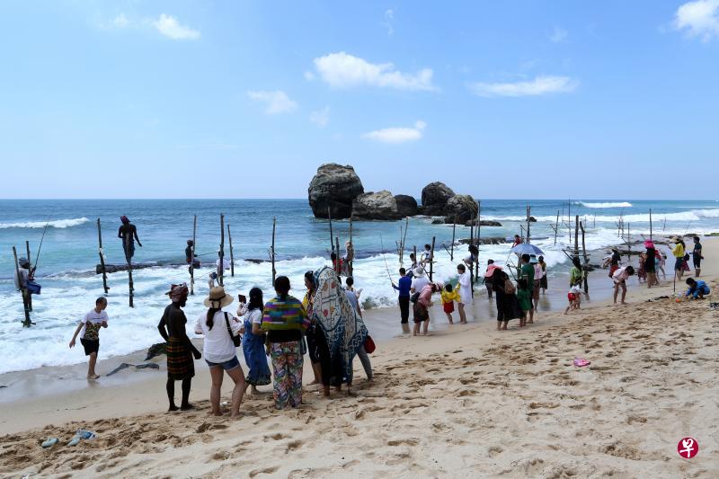 在斯里兰卡南部高尔的海边,传统的高跷钓鱼法成了外国游客猎奇的热点,其中很多就是中国游客。(彭博社) 在斯里兰卡南部高尔的海边,传统的高跷钓鱼法成了外国游客猎奇的热点,其中很多就是中国游客。(彭博社)