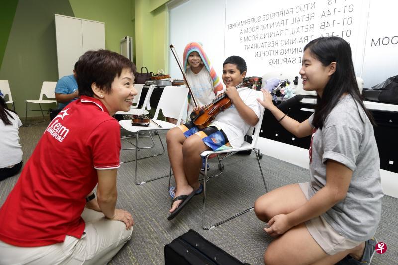 傅海燕指出,开放机会让不同社会背景的人,尤其弱势家庭的孩子也能参与艺术、体育及义工项目,有助启发他们积极向上。图为傅海燕(左)同音乐教育活动Project Infinitude的参与者互动。这个活动以弱势儿童为对象。(文社青部提供) 傅海燕指出,开放机会让不同社会背景的人,尤其弱势家庭的孩子也能参与艺术、体育及义工项目,有助启发他们积极向上。图为傅海燕(左)同音乐教育活动Project Infinitude的参与者互动。这个活动以弱势儿童为对象。(文社青部提供)