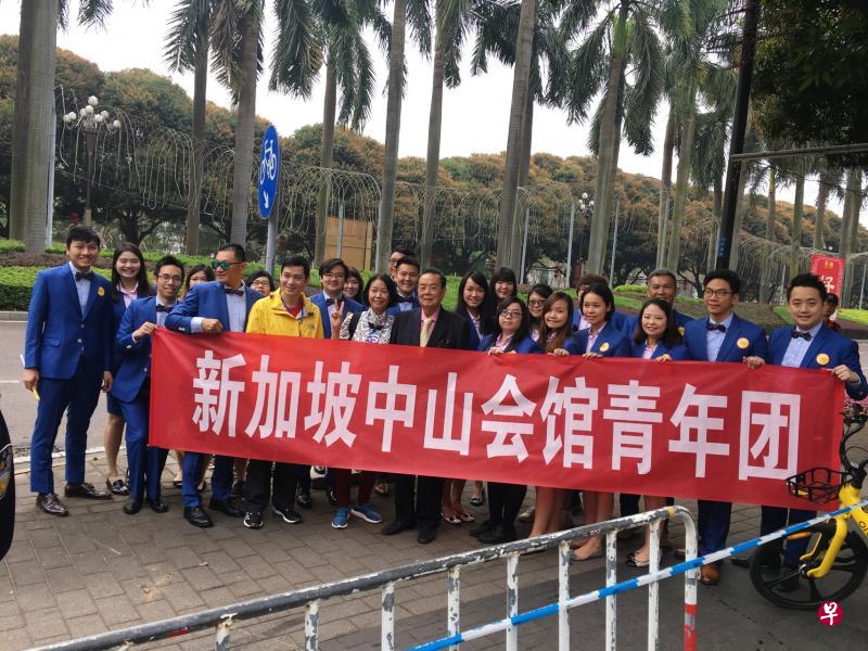 在慈善万人行开始前，许社佳（前排中穿深色大衣者）跟首次参加巡游的青年团员合影留念。（受访者提供）