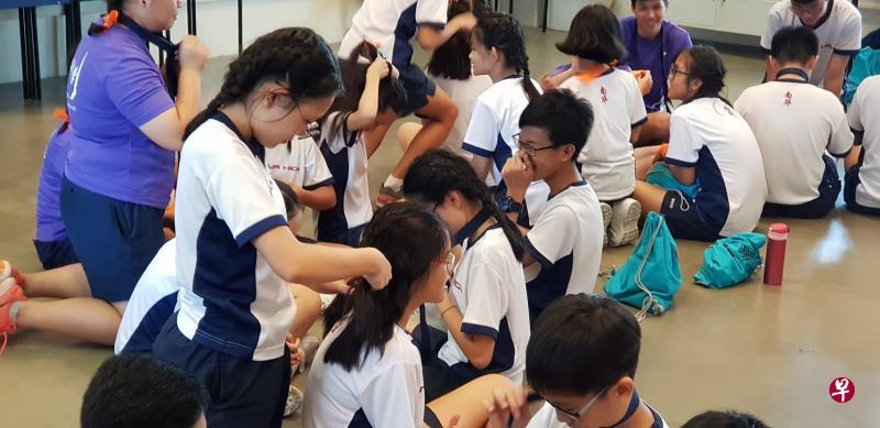 中二的学生教导中一新生扎辫子。 中二的学生教导中一新生扎辫子。