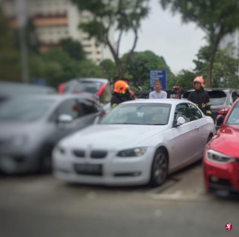 女婴一度受困于白色宝马轿车内,民防人员接到通报到场。(受访者提供) 女婴一度受困于白色宝马轿车内,民防人员接到通报到场。(受访者提供)