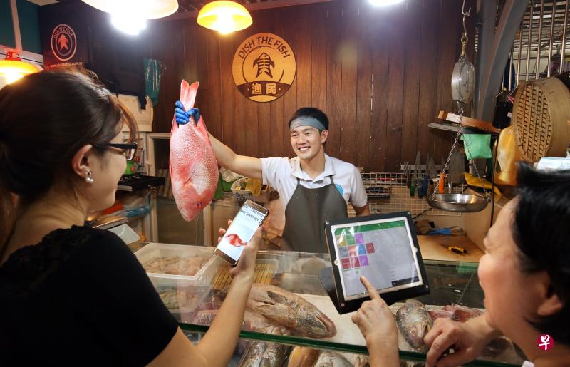 陈俊子在庙弯巴刹开设鱼摊“渔民”,以光鲜干净的店面吸引顾客。(档案照) 陈俊子在庙弯巴刹开设鱼摊“渔民”,以光鲜干净的店面吸引顾客。(档案照)