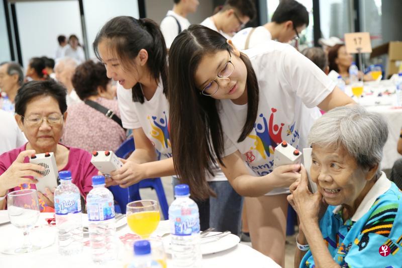 学生义工林沁仪(右二)在活动上,为参与活动的独居老人苏燕霞(右一)解释如何使用融合感应灯和收音机的仪器。(何家俊摄) 学生义工林沁仪(右二)在活动上,为参与活动的独居老人苏燕霞(右一)解释如何使用融合感应灯和收音机的仪器。(何家俊摄)