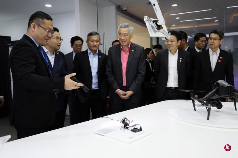 远景创始人兼总裁张雷(左二)和副总经理兼光伏业务总经理孙捷(左一)向李显龙总理(右三)一行介绍太阳能跟踪器等公司研发的新科技。(何家俊摄) 远景创始人兼总裁张雷(左二)和副总经理兼光伏业务总经理孙捷(左一)向李显龙总理(右三)一行介绍太阳能跟踪器等公司研发的新科技。(何家俊摄)