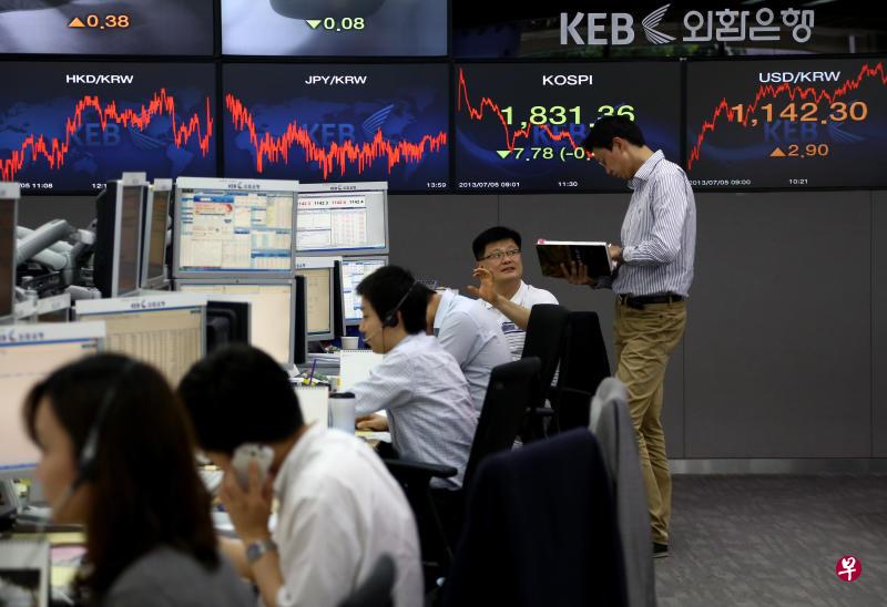 2013年7月5日,在首尔的韩国外换银行总部交易室的职员在工作。(彭博社) 2013年7月5日,在首尔的韩国外换银行总部交易室的职员在工作。(彭博社)
