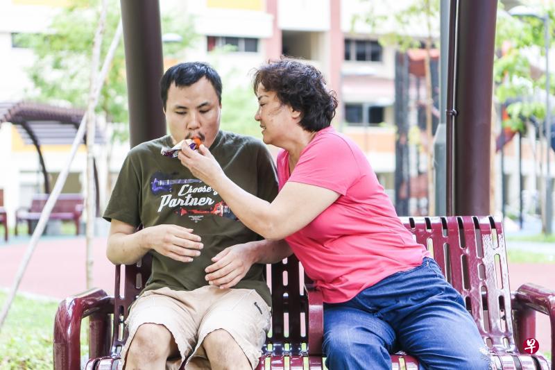 李秋香（右）每天傍晚都会带儿子林国雄到住家楼下的邻里花园走动一小时，而不会让儿子一整天都窝在家中不出门。