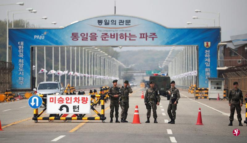 昨天在非军事区不远的统一大桥上,士兵在检查站执勤。这条位于韩国坡州市(Paju)的公路桥直通峰会地点,大桥上挂起标语,最上端的小黑字是:“走向统一的关口”,下面的红字是:“准备统一的坡州”。(路透社) 昨天在非军事区不远的统一大桥上,士兵在检查站执勤。这条位于韩国坡州市(Paju)的公路桥直通峰会地点,大桥上挂起标语,最上端的小黑字是:“走向统一的关口”,下面的红字是:“准备统一的坡州”。(路透社)