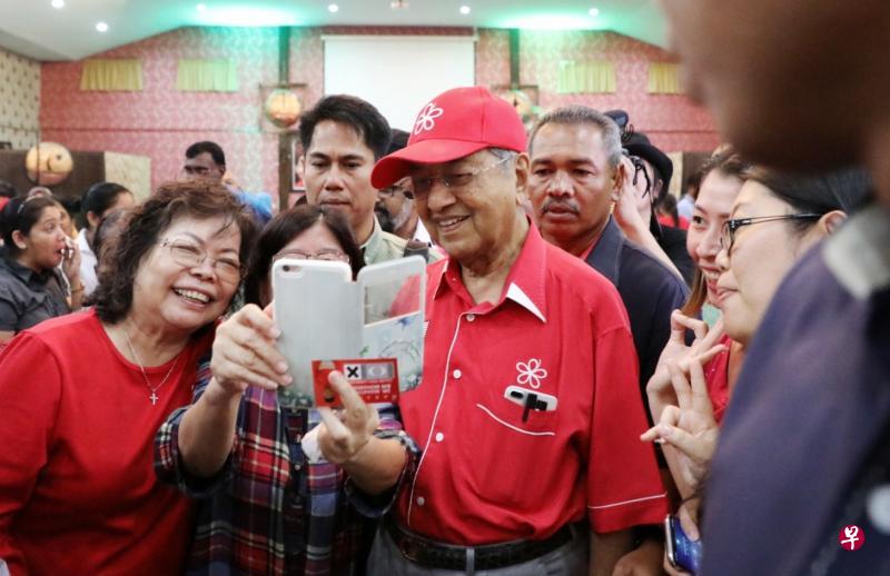 马哈迪(左三)提名日前夕在浮罗交怡出席希盟妇女组的聚会,争取各族妇女选票。他在活动上成为大家竞相合照的对象。(林国明摄) 马哈迪(左三)提名日前夕在浮罗交怡出席希盟妇女组的聚会,争取各族妇女选票。他在活动上成为大家竞相合照的对象。(林国明摄)