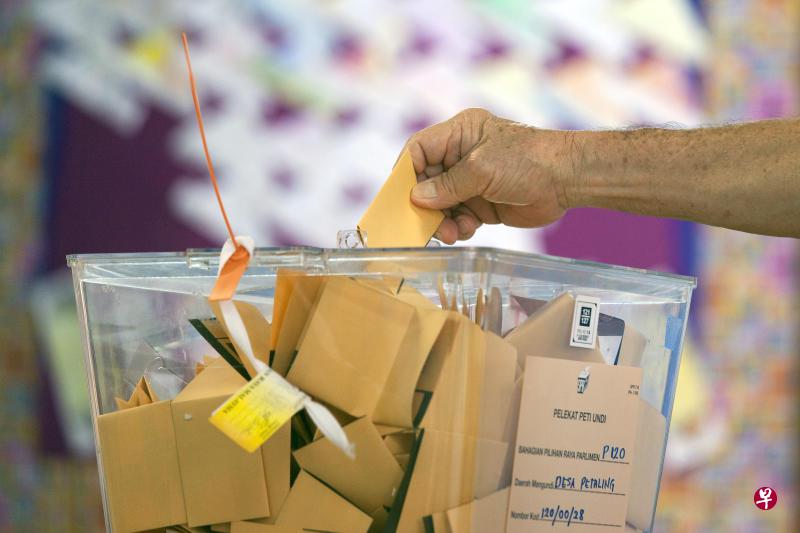 2018年5月9日,到吉隆坡Desa Petaling区投票的一个选民把票投入箱子。(彭博社) 2018年5月9日,到吉隆坡Desa Petaling区投票的一个选民把票投入箱子。(彭博社)