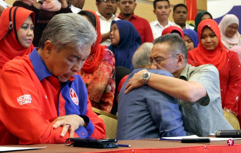 纳吉在记者会上宣布辞任国阵及巫统主席之后,巫统副主席希山慕丁(右一)转身拥抱他,他们俩是表兄弟。一旁的巫统署理主席阿末扎希(左一)也垂头丧气。(星洲日报) 纳吉在记者会上宣布辞任国阵及巫统主席之后,巫统副主席希山慕丁(右一)转身拥抱他,他们俩是表兄弟。一旁的巫统署理主席阿末扎希(左一)也垂头丧气。(星洲日报)