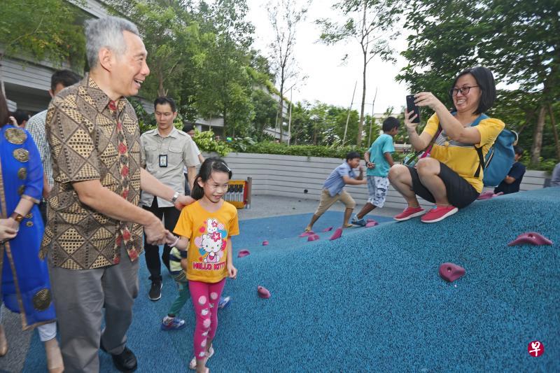 李显龙总理(左一)昨天为海军部村庄主持开幕时顺道参观内部设施如游乐场,并与居民近距离互动。(梁伟康摄) 李显龙总理(左一)昨天为海军部村庄主持开幕时顺道参观内部设施如游乐场,并与居民近距离互动。(梁伟康摄)