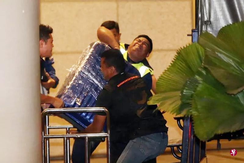 警员费力地抬起沉重的行李箱,相信装有许多金饰财物。(星洲日报) 警员费力地抬起沉重的行李箱,相信装有许多金饰财物。(星洲日报)