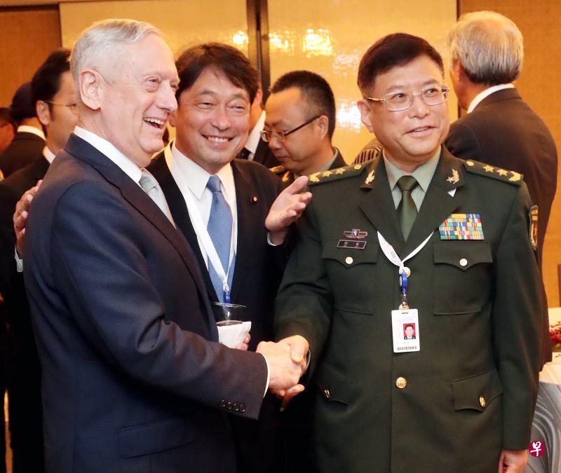 美国防长马蒂斯（左）和中国军事科学院副院长何雷（右）昨天出席香格里拉对话。两人虽在同日较早时候因南中国海课题“互呛”，但是在会议上仍微笑握手，站在两人中间的是日本国防部长小野寺五典。（陈来福摄）