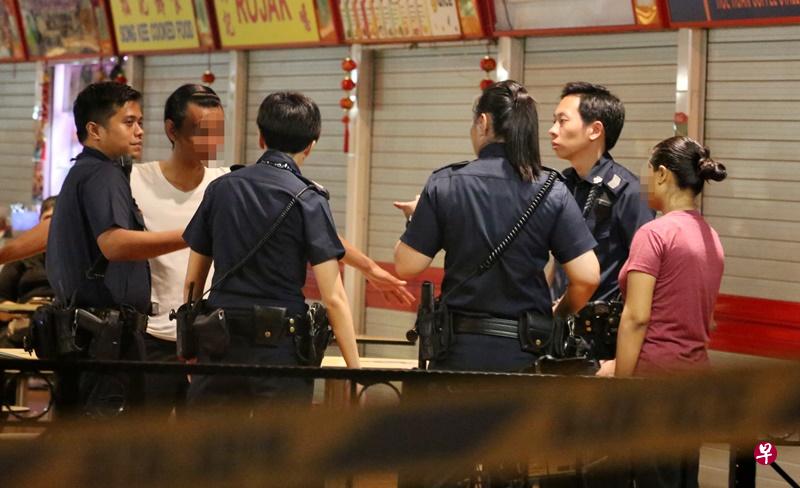 一男一女被警员带到熟食中心内问话。(陈佩敏 摄) 一男一女被警员带到熟食中心内问话。(陈佩敏 摄)