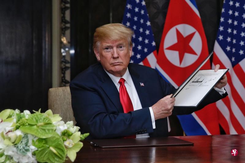 特朗普向媒体出示了他和金正恩签署的联合声明。(海峡时报) 特朗普向媒体出示了他和金正恩签署的联合声明。(海峡时报)