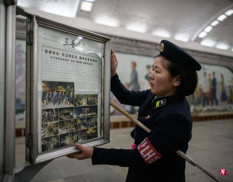 昨天在平壤一个地铁站,工作人员在新闻看板上贴出了《劳动新闻》的封面,上面用了14张照片介绍金正恩前一晚夜游新加坡。(法新社) 昨天在平壤一个地铁站,工作人员在新闻看板上贴出了《劳动新闻》的封面,上面用了14张照片介绍金正恩前一晚夜游新加坡。(法新社)