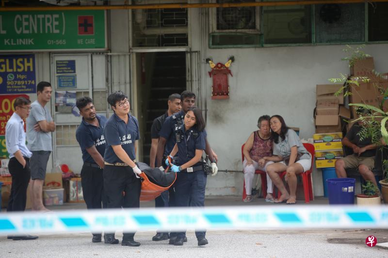 警察和仵作把黄绍光的遗体抬离发生意外的饼家。(海峡时报) 警察和仵作把黄绍光的遗体抬离发生意外的饼家。(海峡时报)