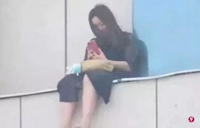 李奕奕跳楼前坐在商场八楼平台上,挣扎了近四个小时。(互联网) 李奕奕跳楼前坐在商场八楼平台上,挣扎了近四个小时。(互联网)