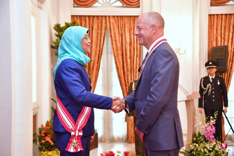 推动新加坡成为生物医药科学枢纽有功的英国制药巨擘葛兰素史克前总裁安伟杰,昨日从哈莉玛总统手中接获荣誉公民奖。(海峡时报) 推动新加坡成为生物医药科学枢纽有功的英国制药巨擘葛兰素史克前总裁安伟杰,昨日从哈莉玛总统手中接获荣誉公民奖。(海峡时报)