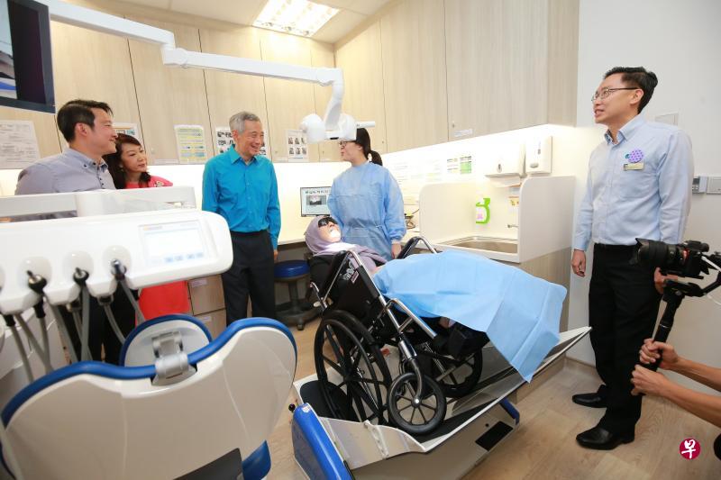 李显龙总理(中)昨天参观宏茂桥综合诊疗所重建后的新设施,包括牙科处最新引进的倾斜轮椅平台。(唐家鸿摄) 李显龙总理(中)昨天参观宏茂桥综合诊疗所重建后的新设施,包括牙科处最新引进的倾斜轮椅平台。(唐家鸿摄)