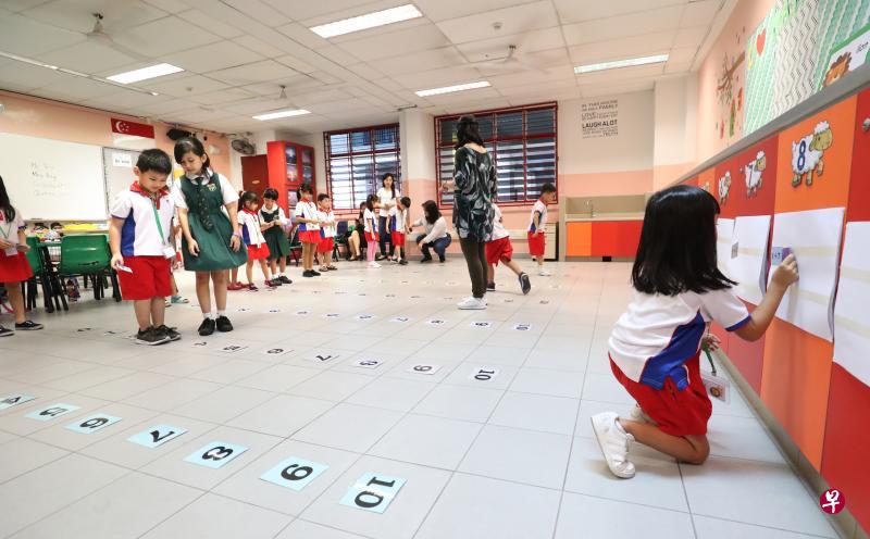 聚英小学数学教师通过游戏教学生加减法,把数字卡贴在地板上,让学生跳到正确的答案上面,让学生的学习体验更有趣。(陈来福摄) 聚英小学数学教师通过游戏教学生加减法,把数字卡贴在地板上,让学生跳到正确的答案上面,让学生的学习体验更有趣。(陈来福摄)