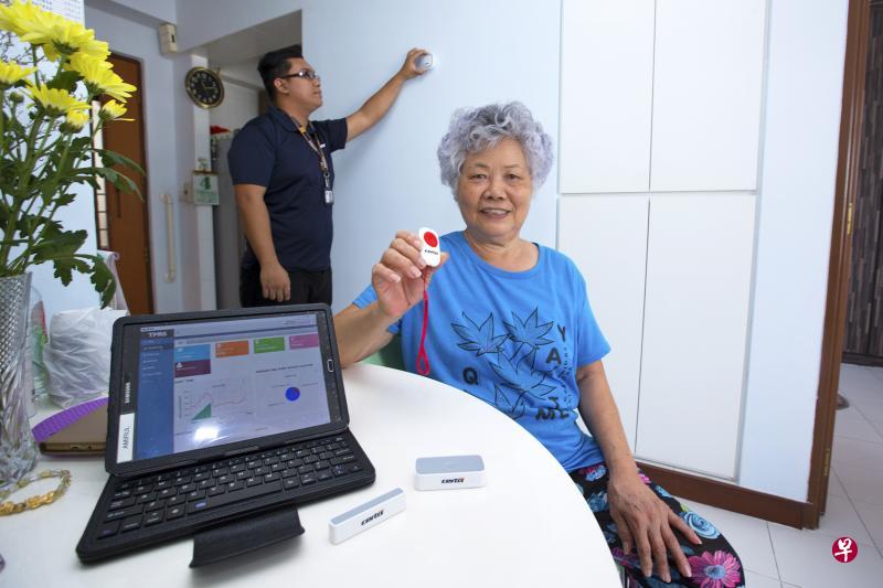裕廊中居民丁亚妹是“居家监测辅助服务”受益者。图为新加坡红十字会安排人员到她的住家安装行动感应器,她的日常作息一旦有异常,就会有人及时提供支援。丁亚妹手中握着的是一个可在紧急情况使用的救助按钮。(曾道明摄) 裕廊中居民丁亚妹是“居家监测辅助服务”受益者。图为新加坡红十字会安排人员到她的住家安装行动感应器,她的日常作息一旦有异常,就会有人及时提供支援。丁亚妹手中握着的是一个可在紧急情况使用的救助按钮。(曾道明摄)