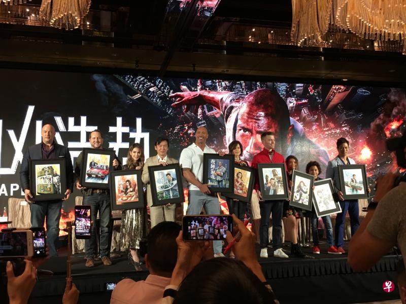 昆凌(左三起)、黄经汉、巨石强森、内芙、导演费巴,童星麦克娜和挪亚在香港宣传《摩天大楼》。他们手中持香港插画师所送的画作。(李亦筠摄) 昆凌(左三起)、黄经汉、巨石强森、内芙、导演费巴,童星麦克娜和挪亚在香港宣传《摩天大楼》。他们手中持香港插画师所送的画作。(李亦筠摄)