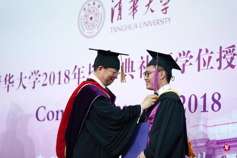 7月8日,清华大学校长邱勇(左)在2018年本科生毕业典礼上为一个本科毕业生整理学位服。(新华社) 7月8日,清华大学校长邱勇(左)在2018年本科生毕业典礼上为一个本科毕业生整理学位服。(新华社)