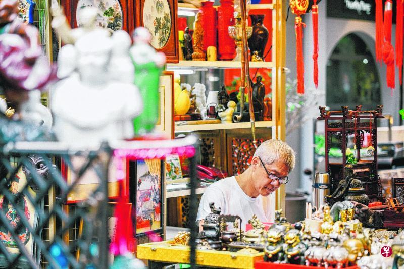 猫街有许多卖中国艺术品的摊位。这摊位售卖许多古色古香的中国饰品和书画,摊主在端详着自己手中的宝物。(邓凯铭/摄) 猫街有许多卖中国艺术品的摊位。这摊位售卖许多古色古香的中国饰品和书画,摊主在端详着自己手中的宝物。(邓凯铭/摄)