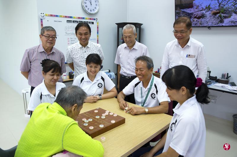 失智症患者全神贯注地跟职员下棋。站立者为视察中心的管理层人员佘文俊(左起)、洪振群、刘孝勇和锺文彪。(曾道明摄) 失智症患者全神贯注地跟职员下棋。站立者为视察中心的管理层人员佘文俊(左起)、洪振群、刘孝勇和锺文彪。(曾道明摄)