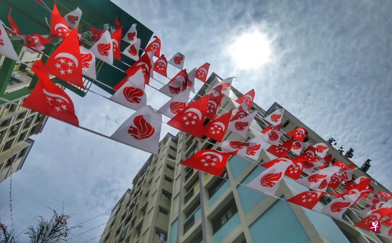 兀兰6道第718座和第720座组屋之间的空中悬挂着一只由彩色小国旗组成的“大蝴蝶”。(林国明摄) 兀兰6道第718座和第720座组屋之间的空中悬挂着一只由彩色小国旗组成的“大蝴蝶”。(林国明摄)